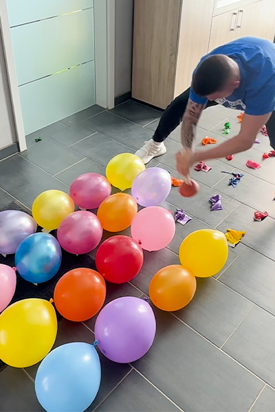 Andre popping balloons with a plunger