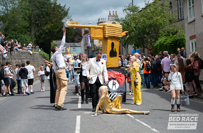 bed race team in James Bond costumes