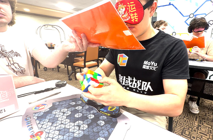 Tommy in a blindfold working on the cube