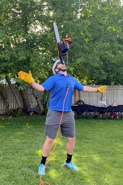 David balancing a chainsaw on his chin