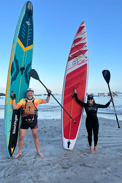the couple on the beach with paddleboards