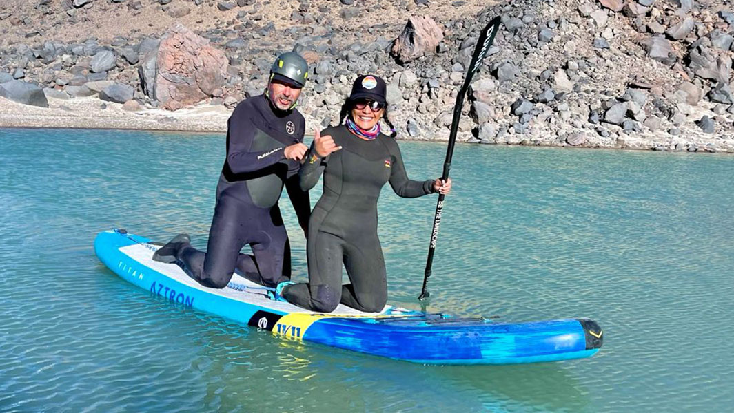 split image of couple doing the highest altitude paddleboard and posing together