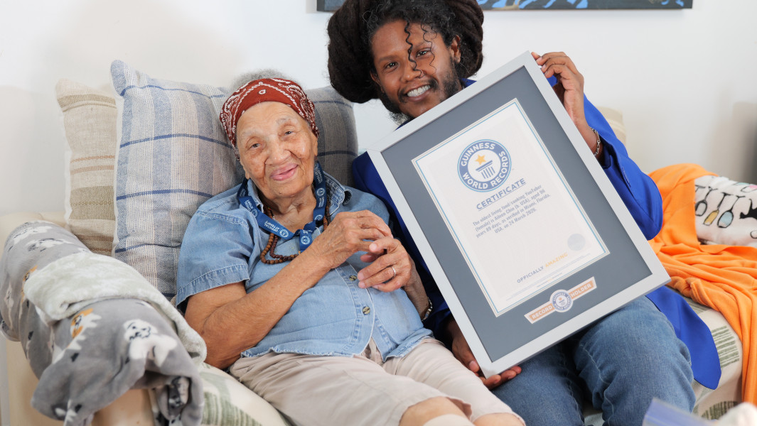 Lucas Wong and Aileen Chin hugging while holding her GWR certificate