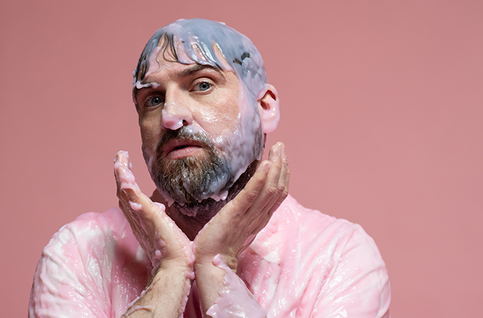 Pictish Trail covered in slime with his hands under his chin