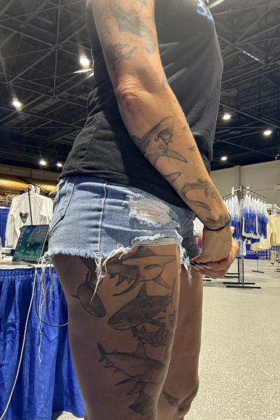 Emily standing to the side and showing off her tattoos