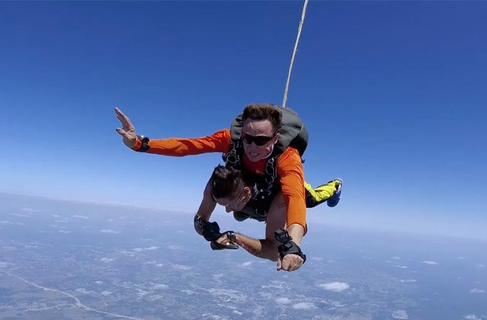 Funky tattooing himself while skydiving