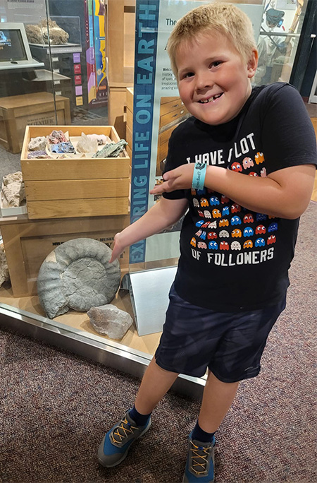 young Anderson posing with fossil