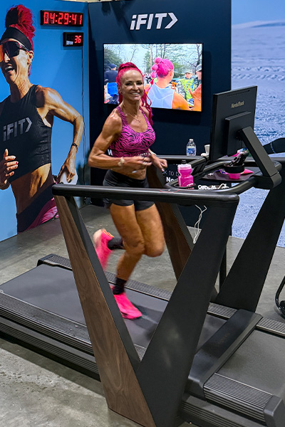 Ashley smiling while running on a treadmill