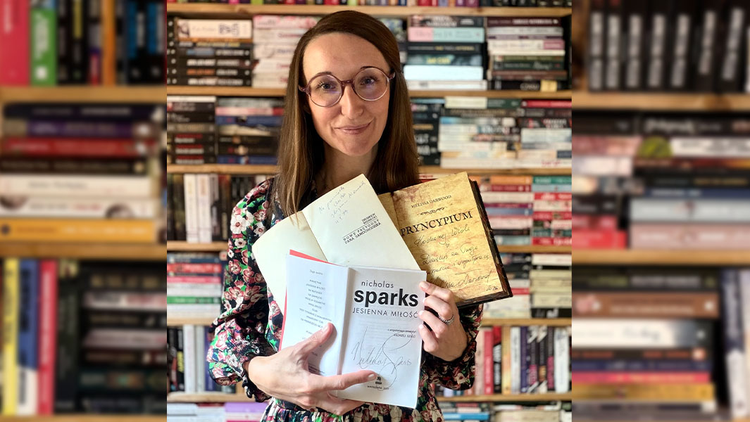 Wioleta holding up some of her autographed books
