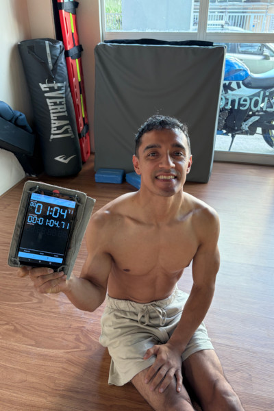 Santiago smiling and holding a timer after his shoulder tap event