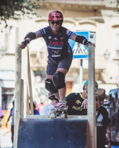 Judi preparing to go downhill at a skateboarding competition in her 60s