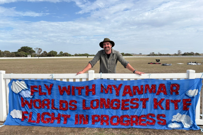 Angus posing with a banner explaining his record attempt