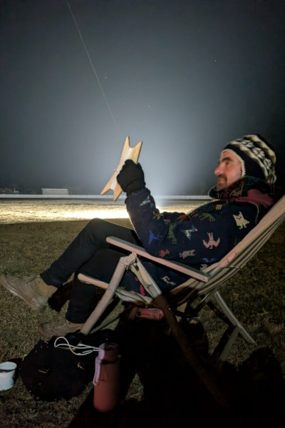 Angus sitting and flying the kite at night