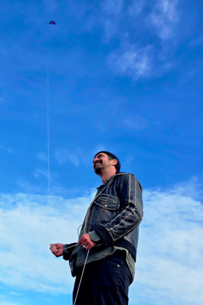 Low angle of Angus flying the kite during daylight