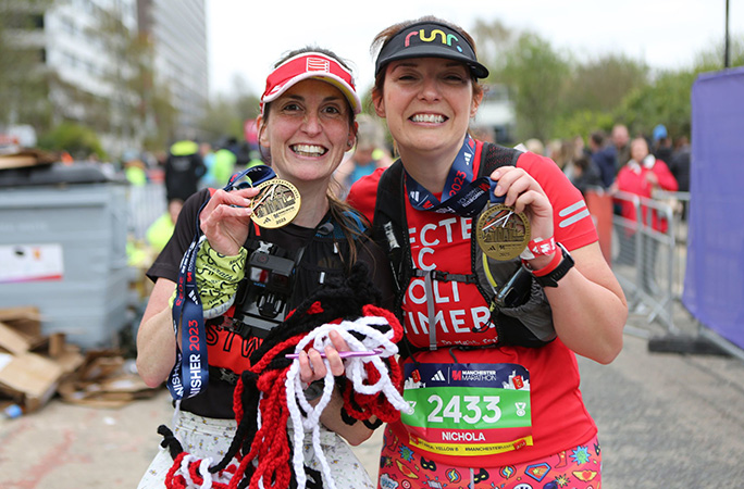 Louise Warwick with her friend holding her medal and crochet chain