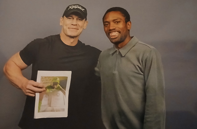 Matthew Akpan and John Cena holding a picture of Matthew during his record attempt