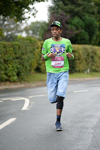 Matthew Akpan running in a green top and jorts
