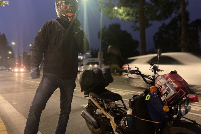 Photo of Jon and his moped together at night