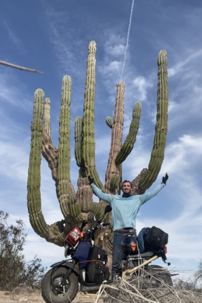 Jon and his moped under a giant cactus