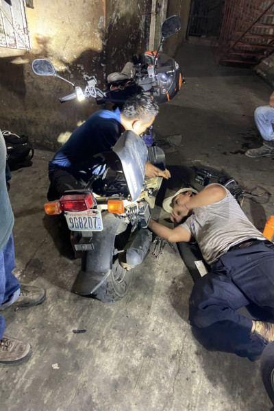 Three men working on Jonathan's moped