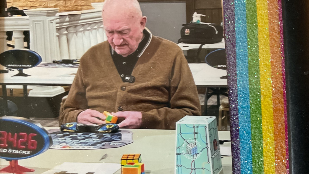 Split image of Frank with his GWR certificate, and Frank competing at the speedcubing event