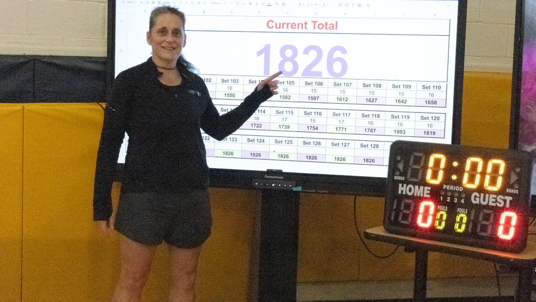 Laura Hunt posing after her attempt with her timecard saying 1,826 push ups