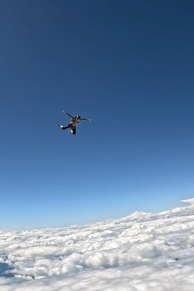 Mark-Olivier with his arms outstretched skydiving with blue skies
