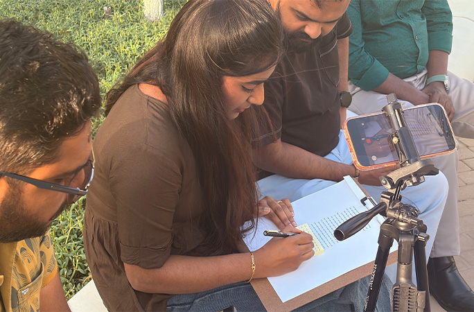 Jothi writing on the sticky note in front of witnesses