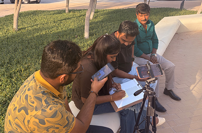 Jothi writing on the sticky note in front of witnesses
