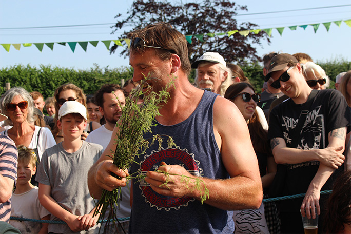 world-stinging-nettle-eating-championship-michael-hobbs-with-2025-trophy-and-stripped-nettle-stems