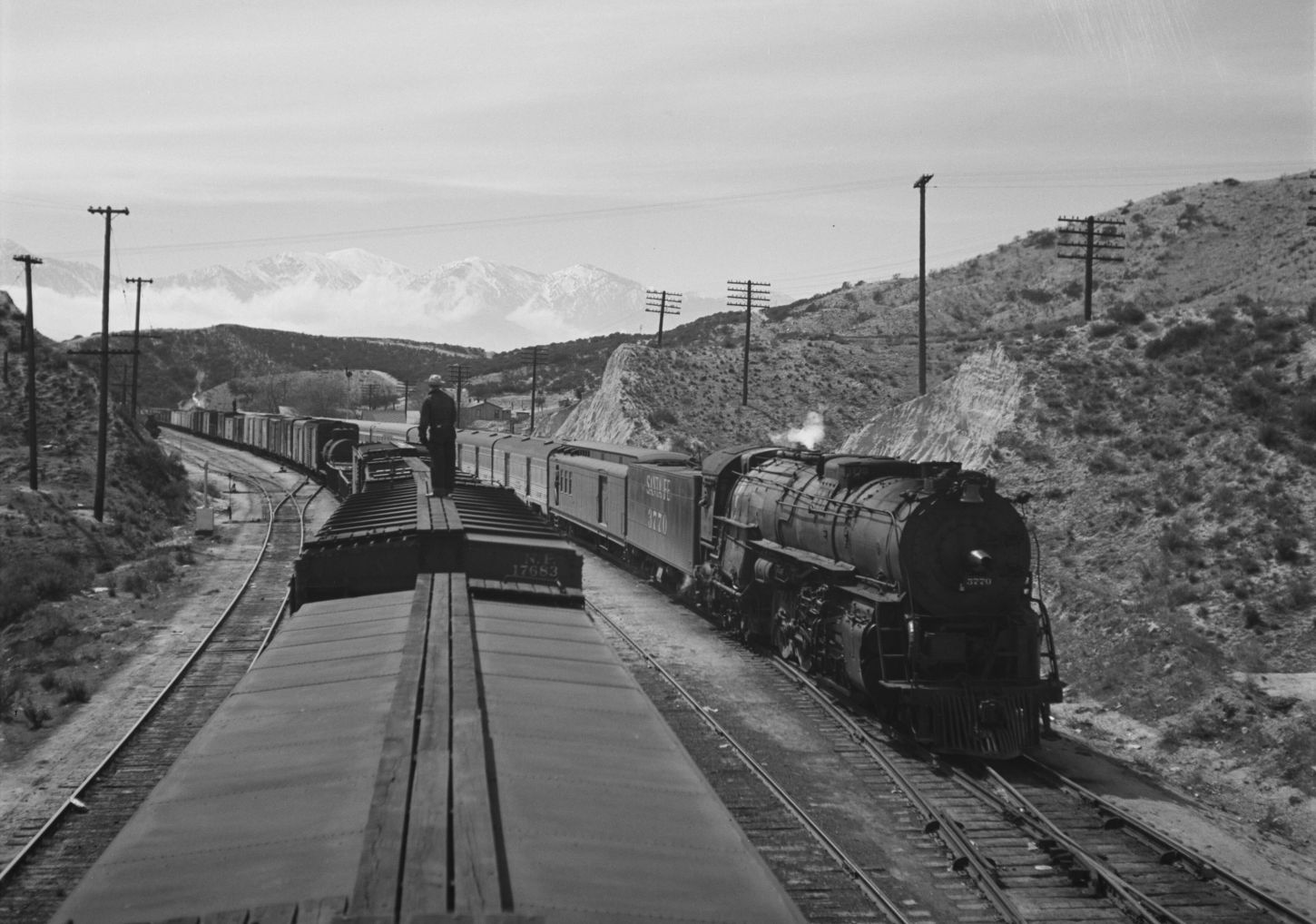 A brakeman riding on top of a train in 1943