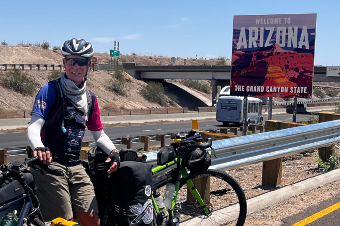 Mark and his bike next to an Arizona road sign