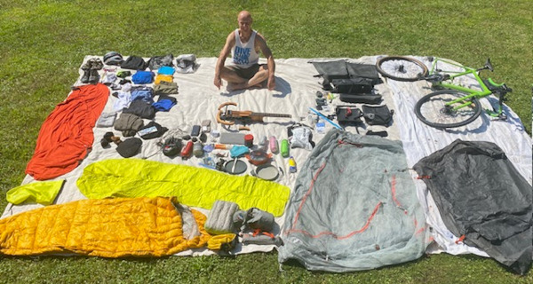 Mark, his bike, and all of his pack items spread out on a blanket
