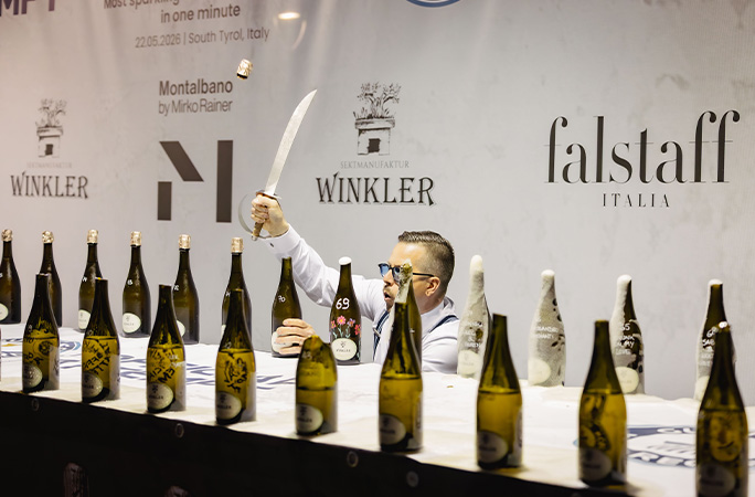 Mirko using a sword to cut the tops off sparkling wine bottles