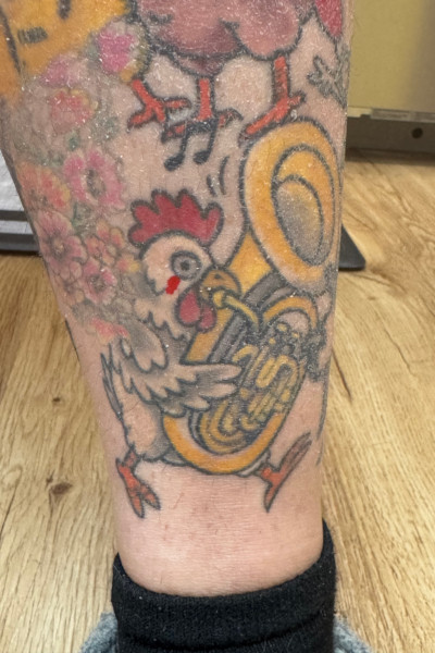 Ashley's tattoo of a chicken playing the tuba