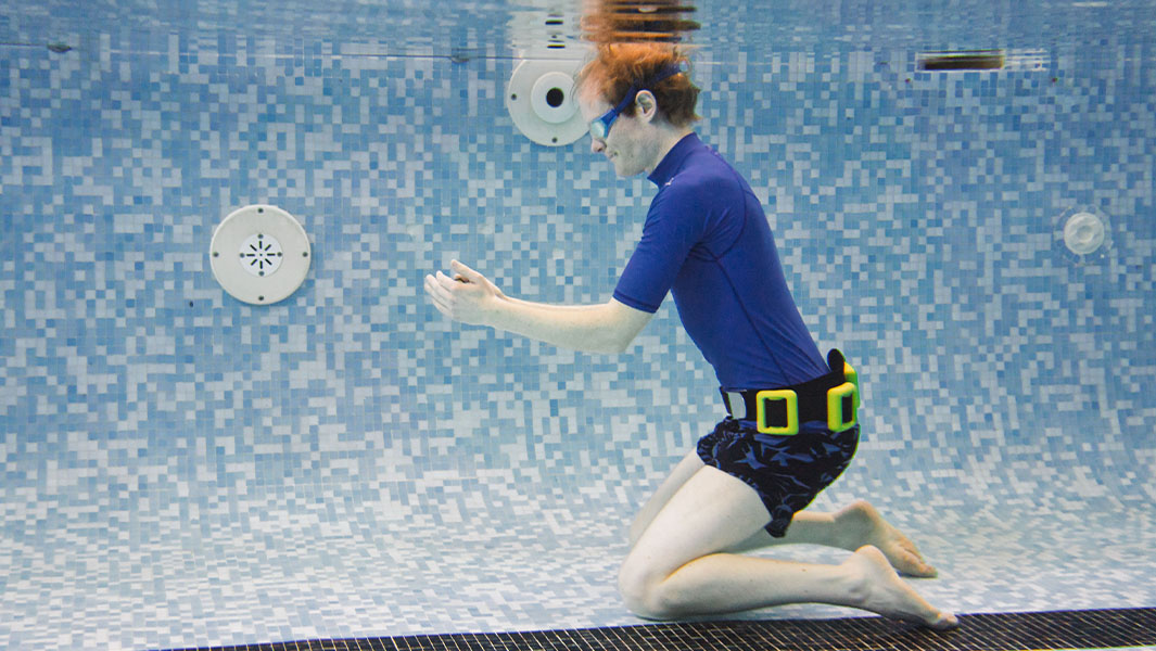 Christian looking at a phone while underwater