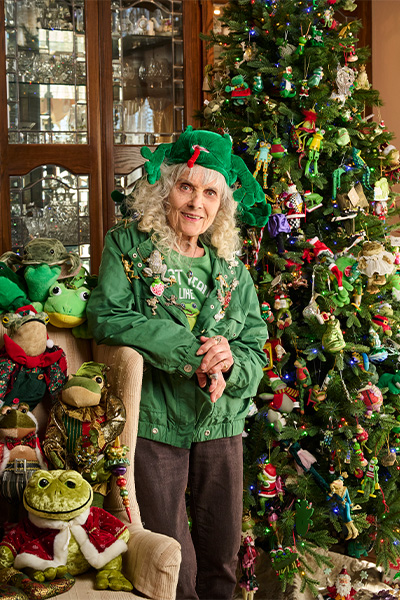 Susan with a Christmas tree covered in frog ornaments