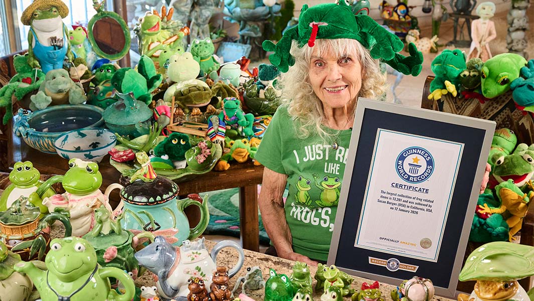 Susan surrounded by her frog collection and holding her GWR certificate