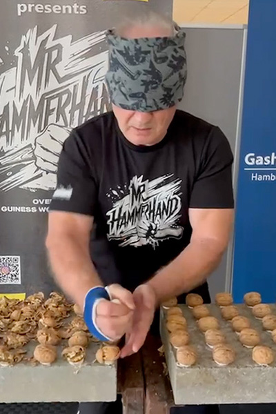 Muahmed crushing walnuts with his hands while blindfolded