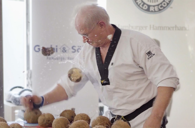 Muhamed smashing coconuts with his hands
