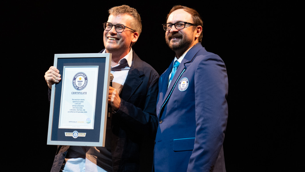 John Green holding GWR certificate onstage with GWR Adjudicator
