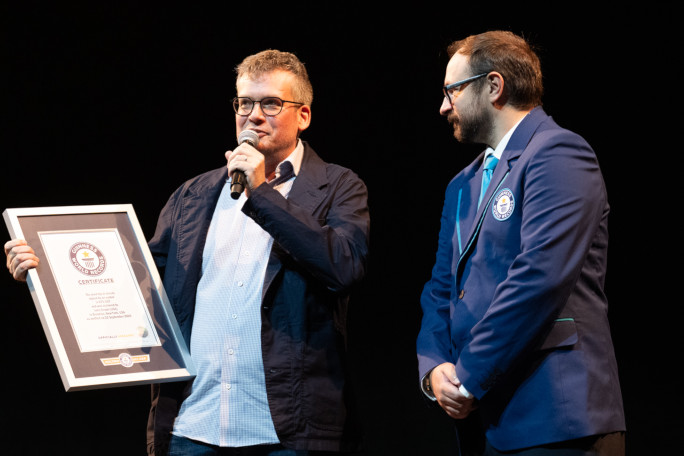 John Green and Adjudicator talking into microphones onstage