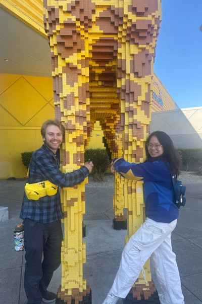 Athena and Sevy hugging a giant LEGO giraffe