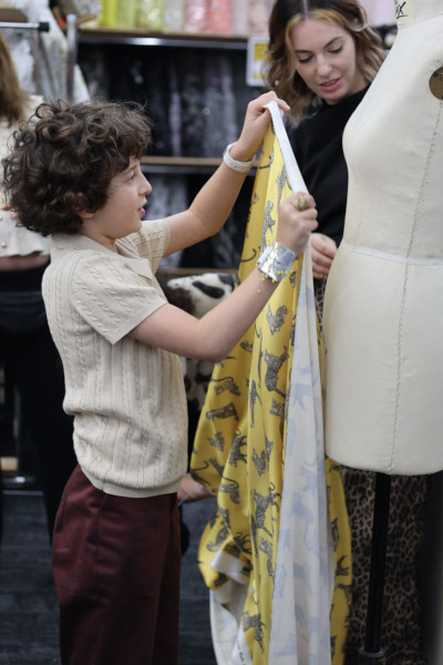 Max pinning a dress on a mannequin with his fabric 