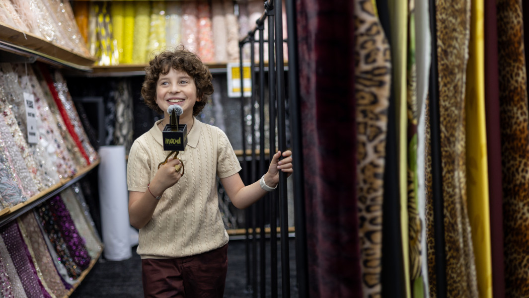 Split header image of Max holding his GWR certificate, and walking next to his fabric line at MOOD