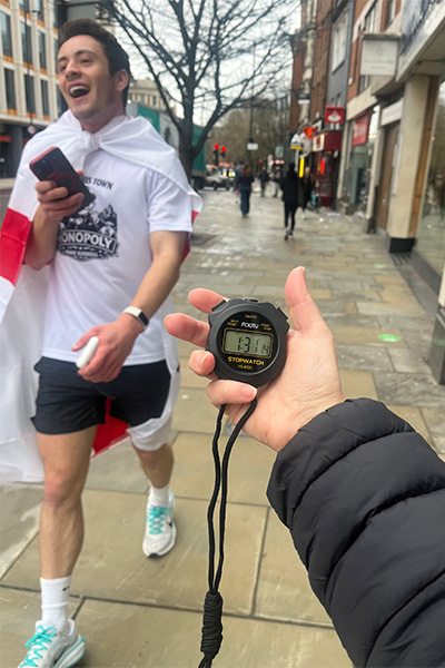 Joabe walking up to someone holding a stopwatch with his final time on it