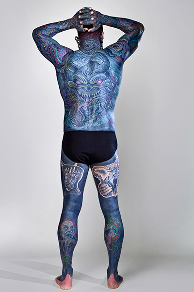 Remy standing with his back to the camera to show off his tattoos