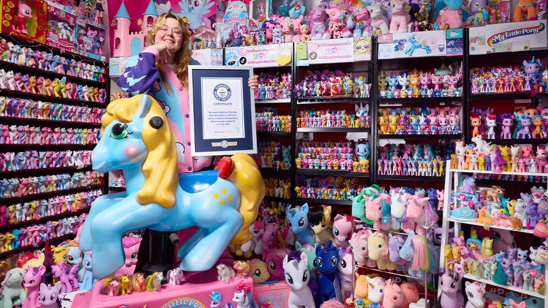 Miranda holding a Guinness World Records certificate and surrounded by her My Little Pony collection
