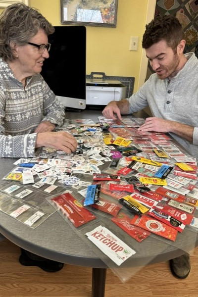 Linda smiling with a friend while going through her packets