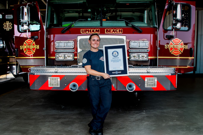 Autumn standing in front of the firetruck, holding her certificate